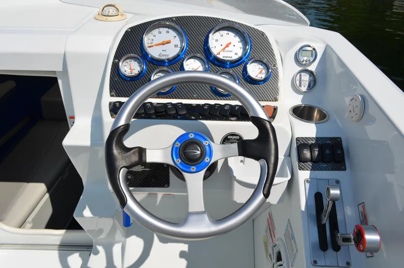 Slide: The Image of Steering wheel and dashboard of a 2008 Baja 26 Outlaw boat with gauges and controls. - 17