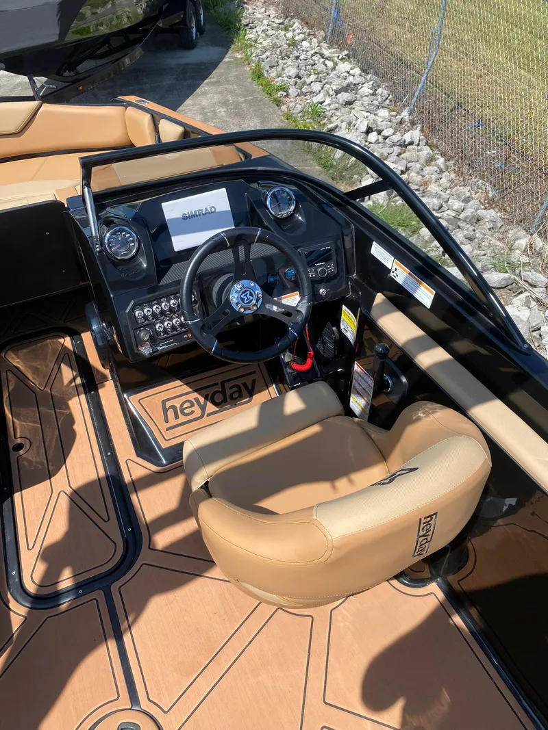 Slide: The Image of 2025 Heyday WT-2DC boat interior with tan seating and modern dashboard controls. - 12