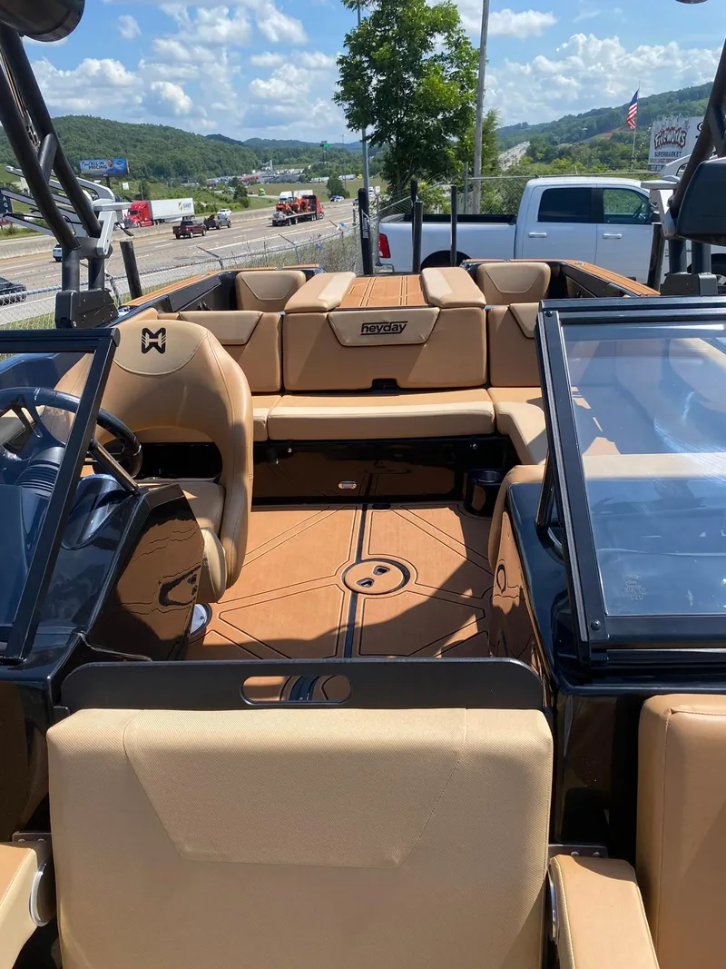 Slide: The Image of 2025 Heyday WT-2DC boat interior with tan seating, open deck, and clear skies. - 14