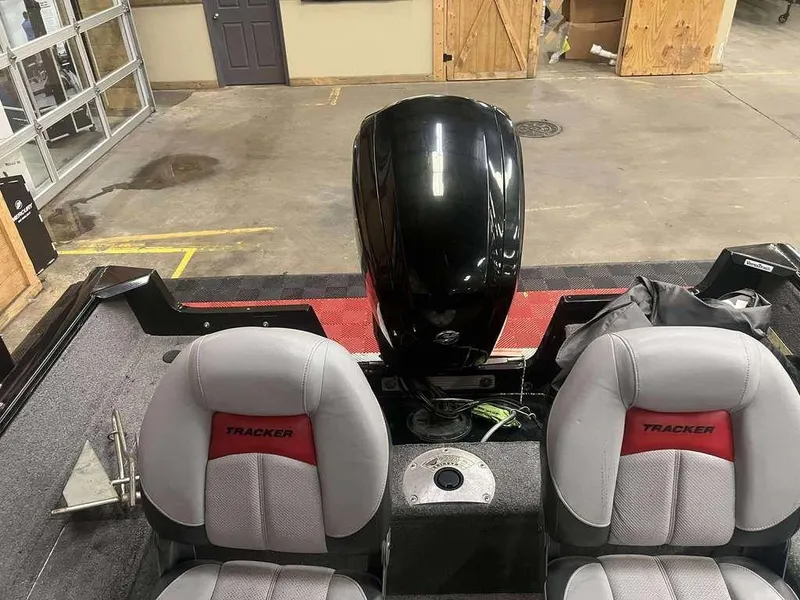 Slide: The Image of 2016 Tracker Pro Guide V-16 WT boat interior with seats and motor in a garage setting. - 7