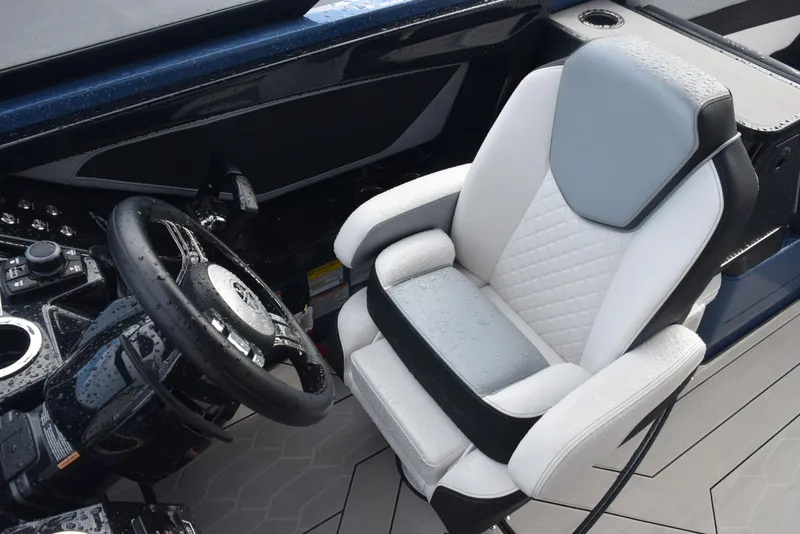 Slide: The Image of 2023 Yamaha Boats 255XD cockpit with sleek steering wheel and cushioned captain's chair. - 12