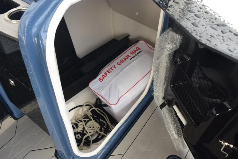 Slide: The Image of Storage compartment in 2023 Yamaha Boats 255XD with safety gear bag and rope. - 18