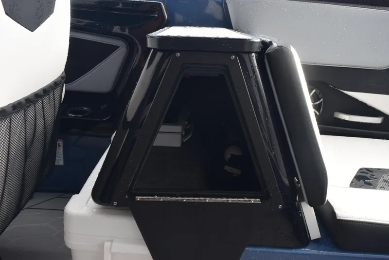 Slide: The Image of 2023 Yamaha Boats 255XD interior storage compartment with sleek black design. - 23