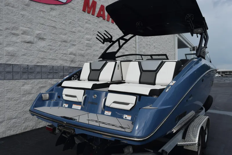 Slide: The Image of 2023 Yamaha Boats 255XD in blue, displayed on a trailer outside a dealership. - 4