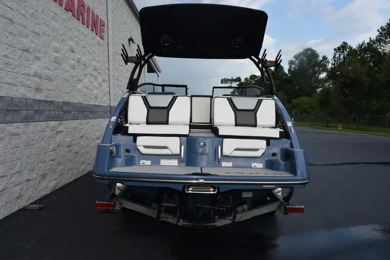 Slide: The Image of 2023 Yamaha Boats 255XD, rear view, parked outdoors, showcasing sleek design and seating. - 5