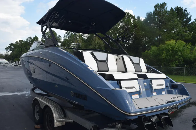 Slide: The Image of 2023 Yamaha Boats 255XD in blue, parked on a trailer, showcasing sleek design and seating. - 6