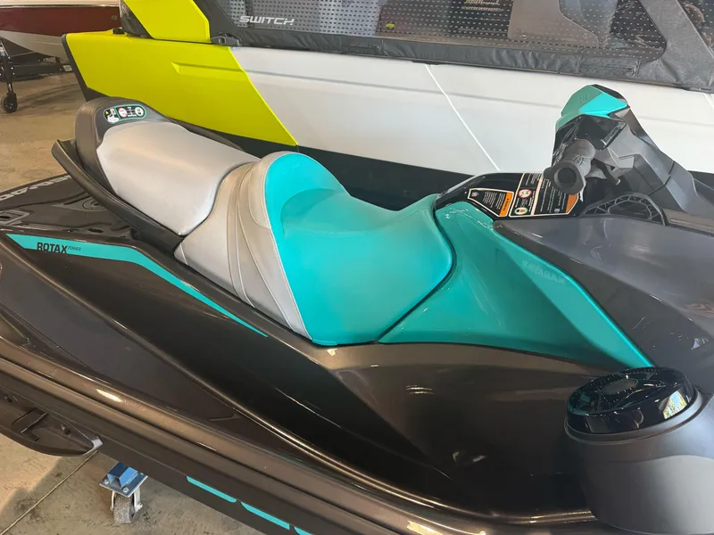 Slide: The Image of 2025 Sea-Doo GTR 230 jet ski with teal and gray seat in showroom. - 3