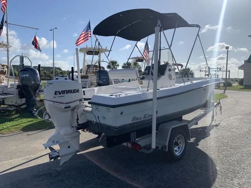 Slide: The Image of 2008 Sea King 180 CC boat with Evinrude engine on trailer, flags in background. - 4