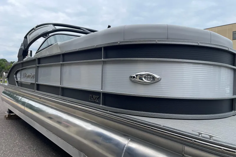 Slide: The Image of 2024 Manitou LX 25 RFXW pontoon boat with sleek design and modern features. - 11