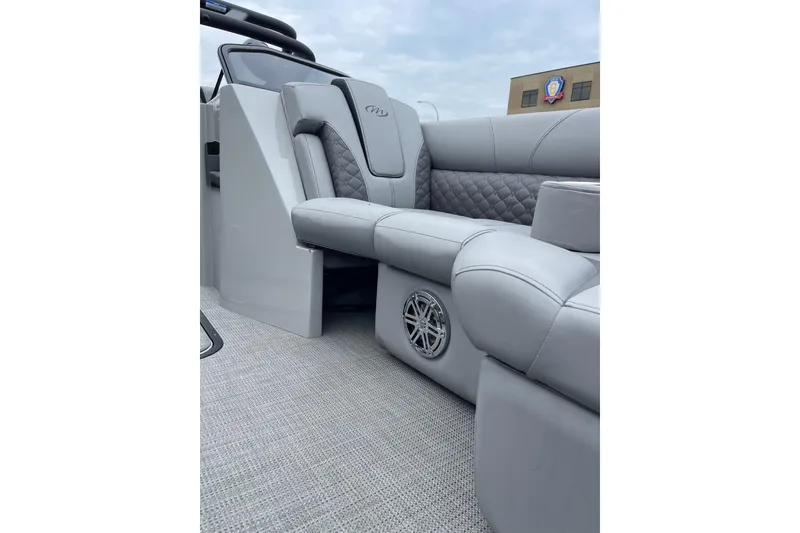 Slide: The Image of 2024 Manitou LX 25 RFXW boat interior with luxurious gray seating and speaker system. - 18