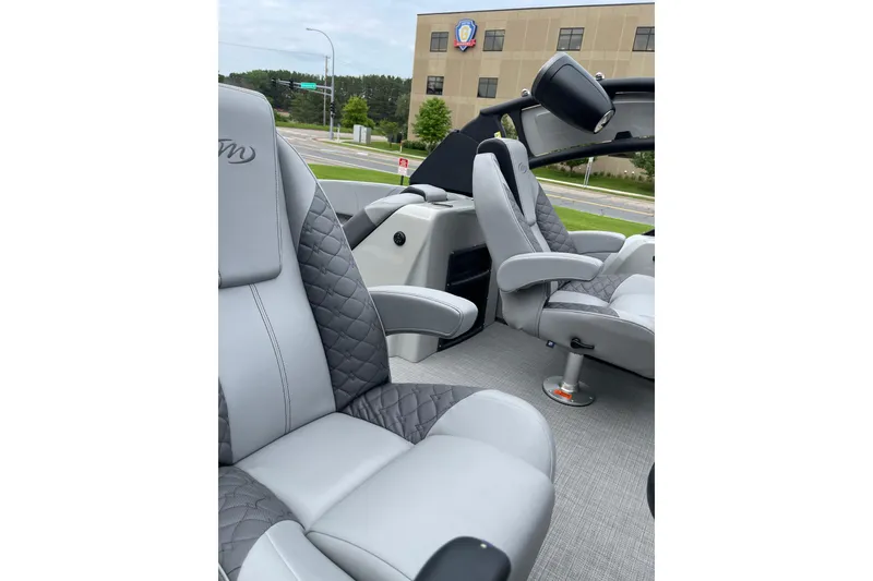 Slide: The Image of 2024 Manitou LX 25 RFXW boat interior with luxurious gray seating and modern design. - 8