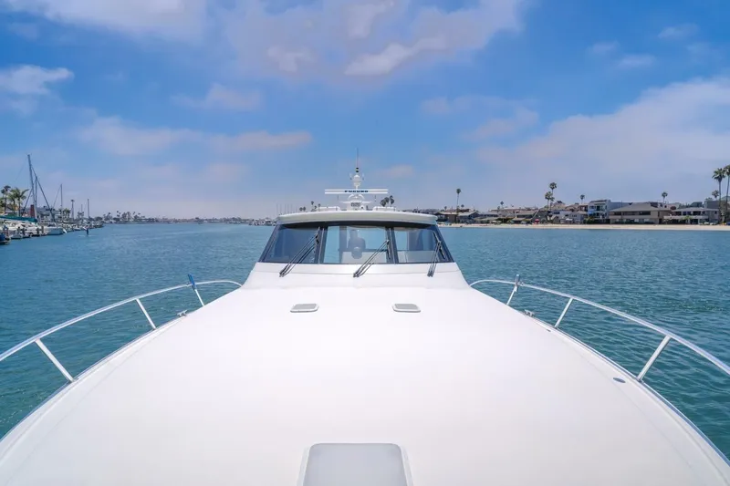 Slide: The Image of 2008 Viking 52 Sport Coupe yacht cruising in a scenic coastal area. - 28