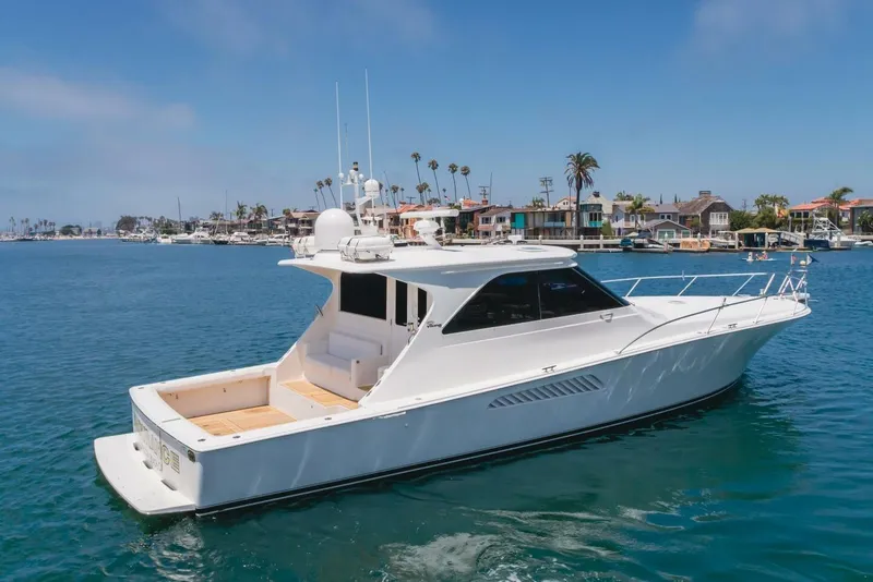 Slide: The Image of 2008 Viking 52 Sport Coupe yacht cruising in a scenic harbor setting. - 35