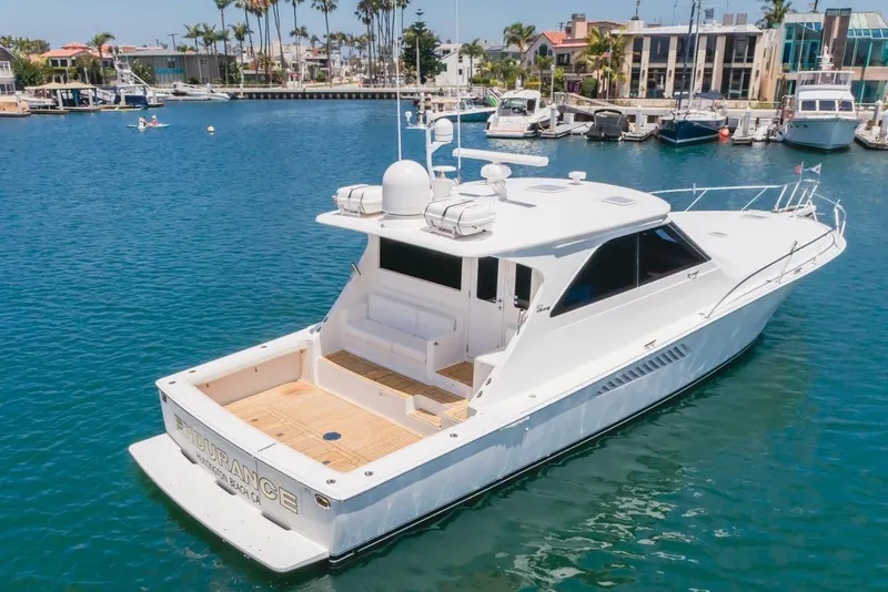 Slide: The Image of 2008 Viking 52 Sport Coupe yacht docked in a marina, surrounded by other boats. - 36