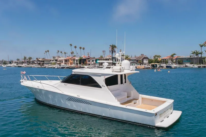 Slide: The Image of 2008 Viking 52 Sport Coupe yacht cruising in a scenic harbor with waterfront homes. - 39