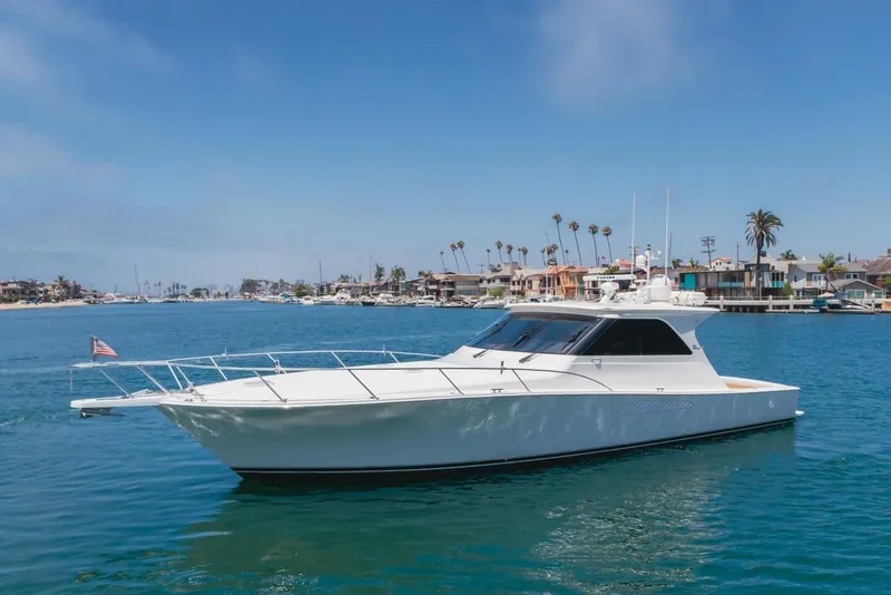 Slide: The Image of 2008 Viking 52 Sport Coupe yacht cruising in a scenic coastal area. - 41