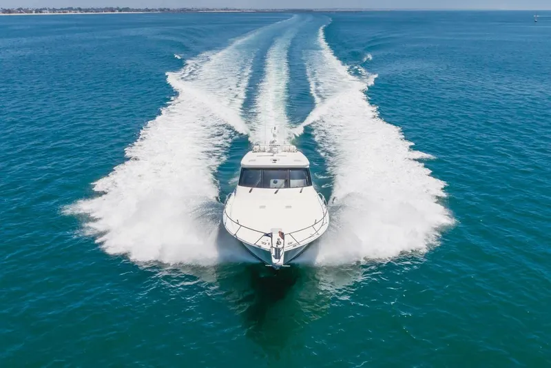 Slide: The Image of 2008 Viking 52 Sport Coupe cruising on open blue water, leaving a wake trail. - 44