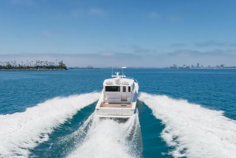 Slide: The Image of 2008 Viking 52 Sport Coupe cruising on blue ocean near city skyline. - 49