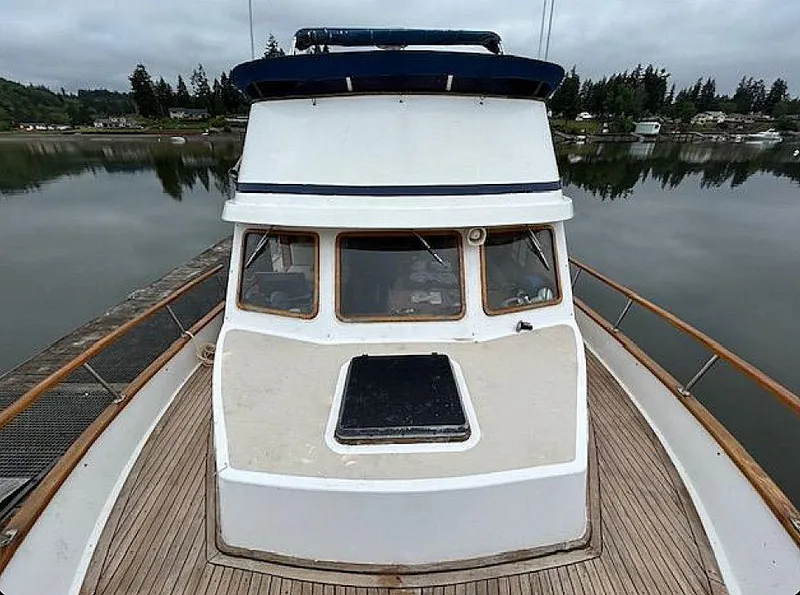 Slide: The Image of 1981 Ocean Double Cabin Trawler on calm water, featuring wooden deck and cabin windows. - 10