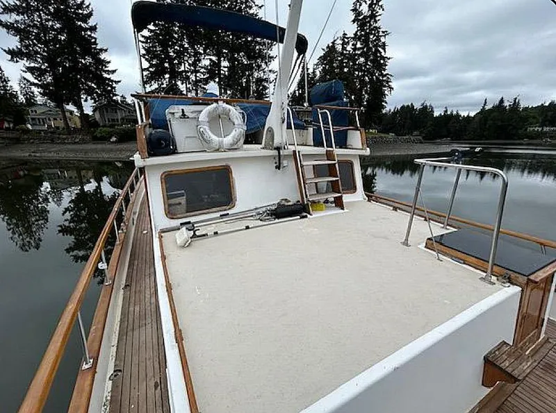 Slide: The Image of 1981 Ocean Double Cabin Trawler on calm water, surrounded by trees and overcast sky. - 11