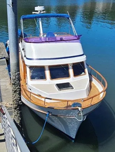 Slide: The Image of 1981 Ocean Double Cabin Trawler docked on calm water, featuring classic design and wooden accents. - 13