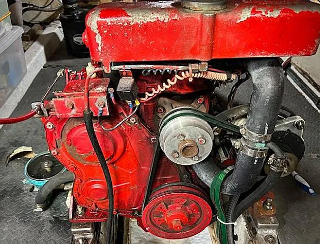 Slide: The Image of Red engine of a 1981 Ocean Double Cabin Trawler, showcasing mechanical components and hoses. - 15