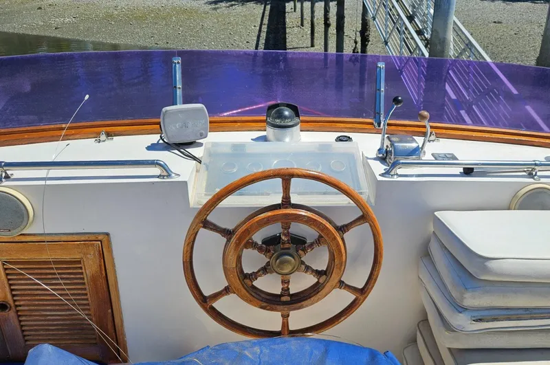 Slide: The Image of 1981 Ocean Double Cabin Trawler helm with wooden wheel and navigation instruments. - 17