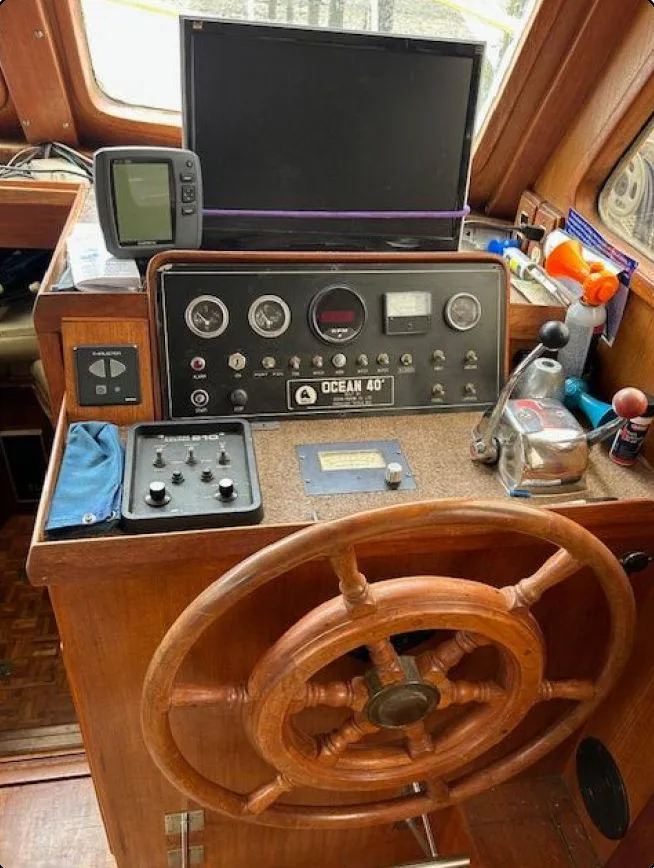 Slide: The Image of 1981 Ocean Double Cabin Trawler helm with wooden wheel and control panel. - 2