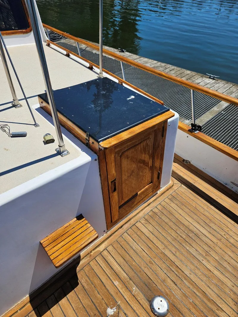 Slide: The Image of 1981 Ocean Double Cabin Trawler deck with wooden details and water view. - 20