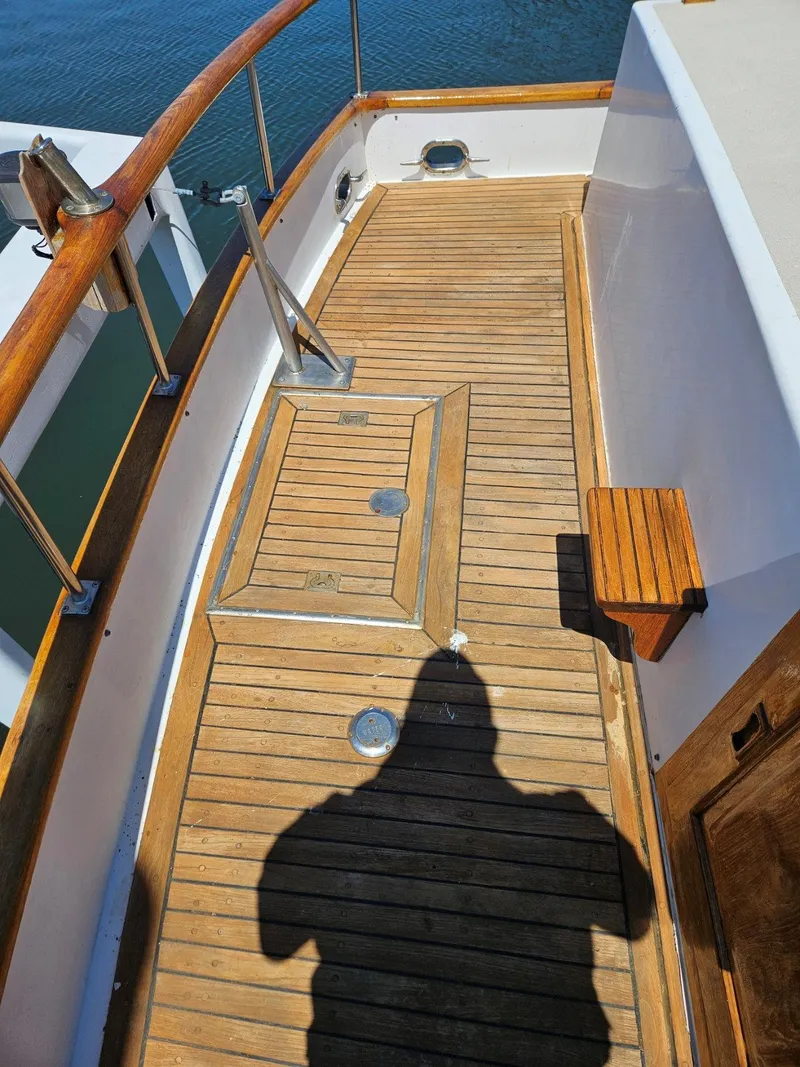 Slide: The Image of Wooden deck of 1981 Ocean Double Cabin Trawler with railing and hatch. - 23