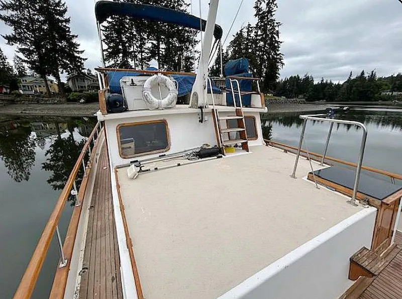 Slide: The Image of 1981 Ocean Double Cabin Trawler on calm water, surrounded by trees and houses. - 25