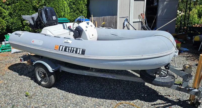 Slide: The Image of Gray inflatable boat on trailer, parked outdoors near a shed. - 26