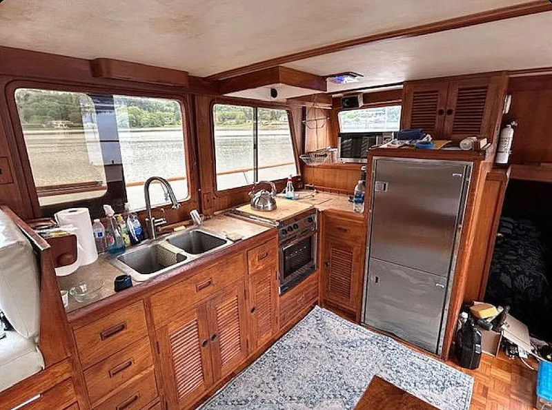 Slide: The Image of Interior of 1981 Ocean Double Cabin Trawler with wooden cabinetry and modern kitchen amenities. - 3