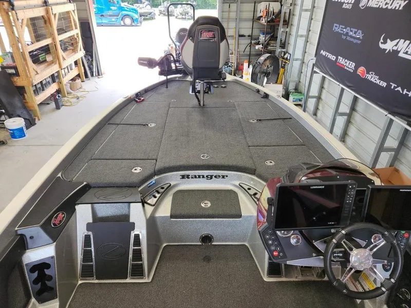 Slide: The Image of 2021 Ranger Z521C boat interior with advanced navigation system and spacious deck in a garage. - 3