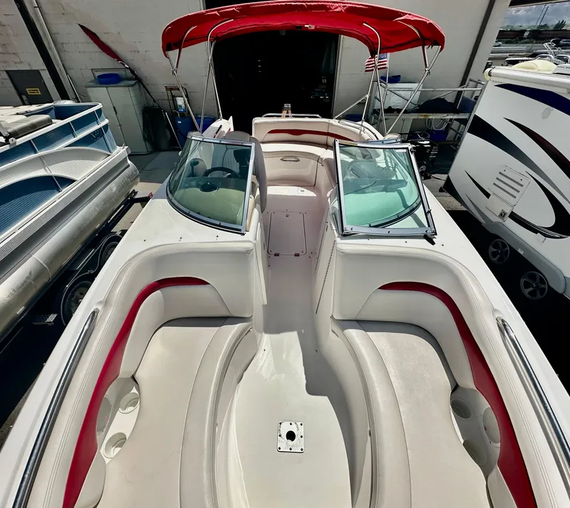 Slide: The Image of 2003 Chaparral 223 Sunesta boat interior with red accents and open deck layout. - 11