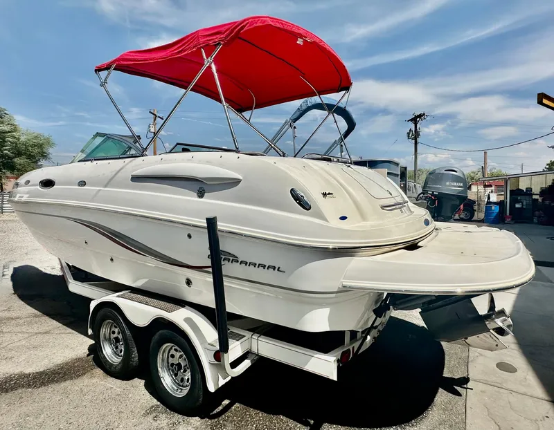 Slide: The Image of 2003 Chaparral 223 Sunesta boat with red canopy on trailer, parked outdoors. - 4