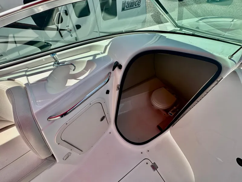Slide: The Image of 2003 Chaparral 223 Sunesta boat interior with compact toilet and sink. - 9
