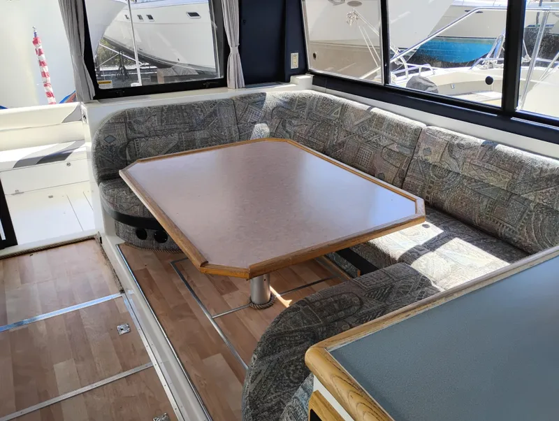 Slide: The Image of Interior of 1992 Bayliner 4388 Motoryacht with cushioned seating and wooden table. - 11