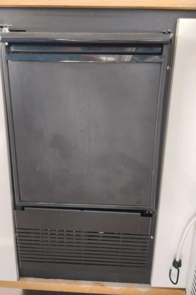 Slide: The Image of 1992 Bayliner 4388 Motoryacht interior fridge, closed, with a sleek black finish. - 14