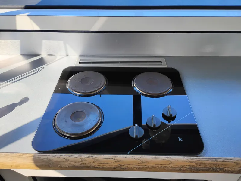 Slide: The Image of Electric stovetop on 1992 Bayliner 4388 Motoryacht, featuring three burners and control knobs. - 17