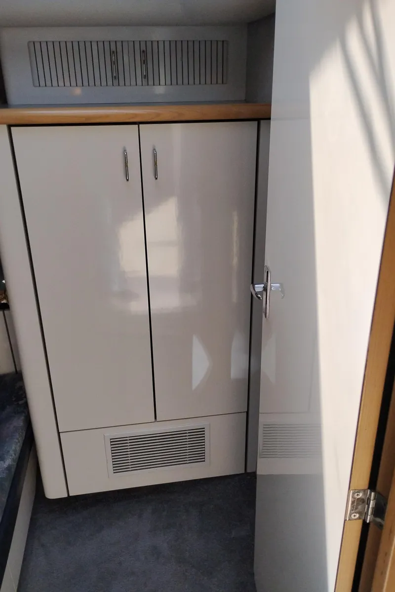 Slide: The Image of Interior of 1992 Bayliner 4388 Motoryacht showing a sleek, white storage cabinet. - 28
