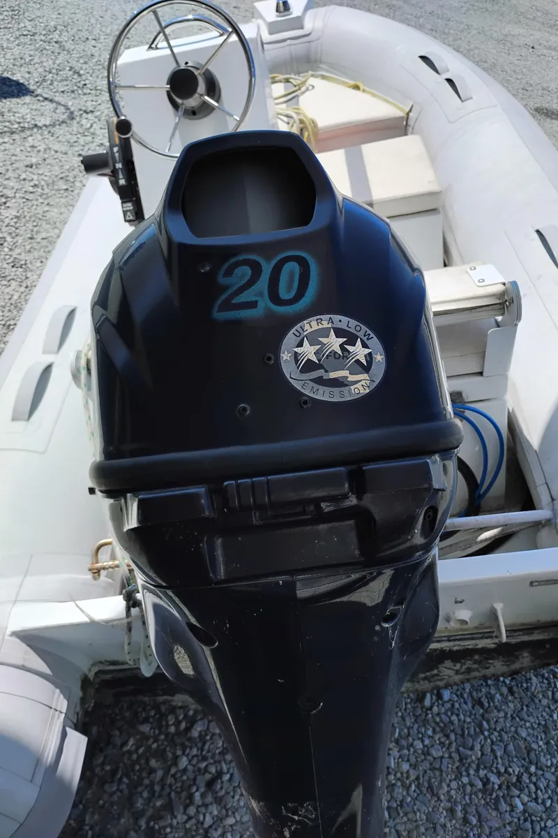 Slide: The Image of Outboard motor on inflatable boat, featuring "Ultra-Low Emissions" badge and steering wheel. - 43