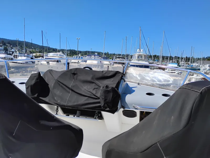 Slide: The Image of 1992 Bayliner 4388 Motoryacht at marina, covered seats, clear blue sky, sailboats in background. - 5