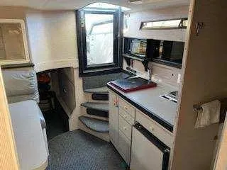 Slide: The Image of 1988 Trojan International boat interior with compact kitchen and seating area. - 11