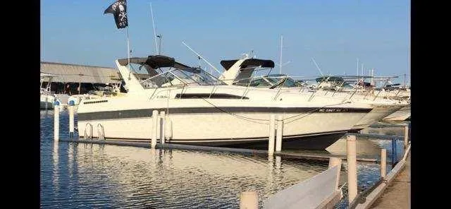 Slide: The Image of 1988 Trojan International boat docked at marina, clear sky, calm water. - 2