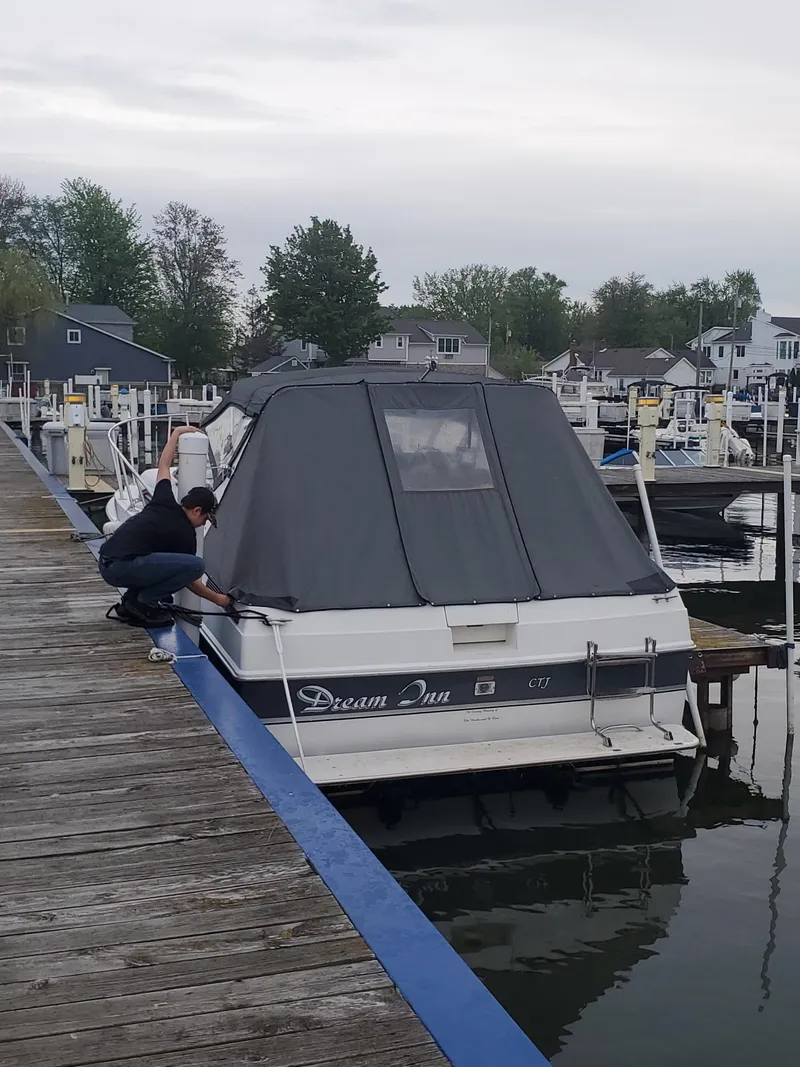 Slide: The Image of Person securing 1988 Trojan International boat named "Dream Inn" at a dock. - 3