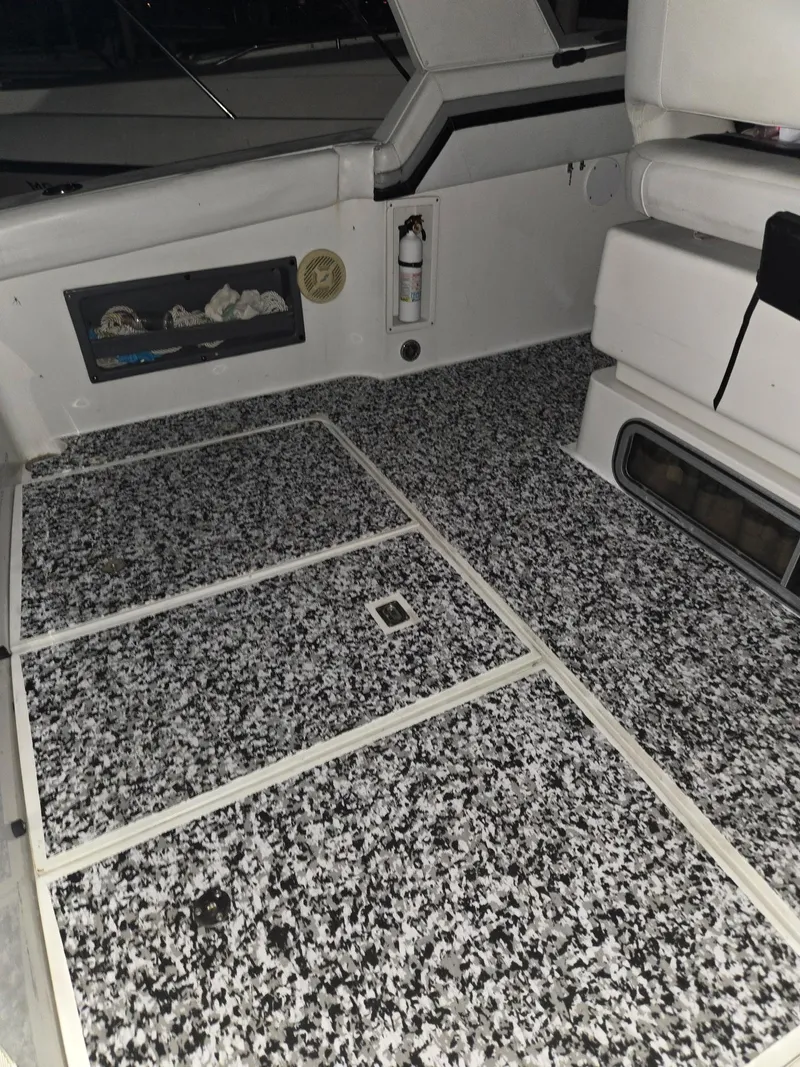Slide: The Image of 1988 Trojan International boat interior with speckled flooring and white seating. - 8