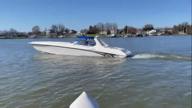The Image of 1999 Fountain 47 Lightning speedboat cruising on a calm lake under a clear blue sky. - 0