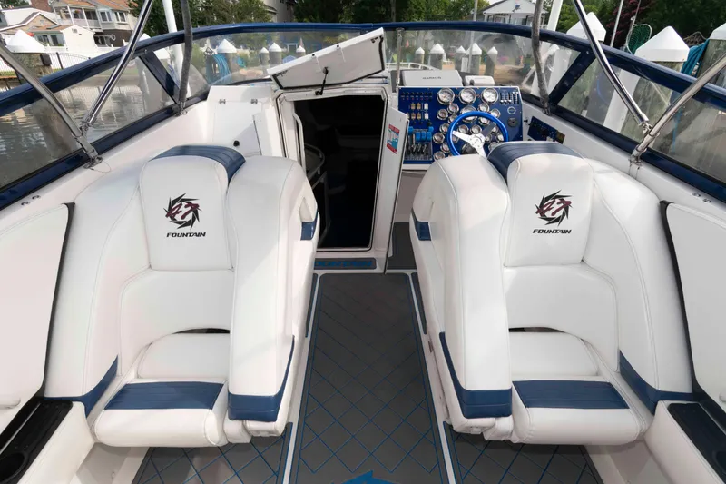 Slide: The Image of 1999 Fountain 47 Lightning boat interior with white and blue seating, dashboard, and steering wheel. - 11