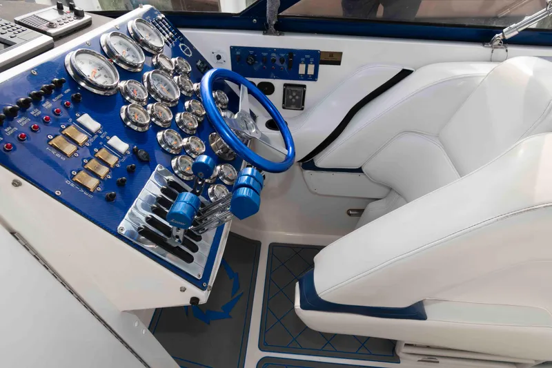 Slide: The Image of Cockpit of 1999 Fountain 47 Lightning boat with blue steering wheel and gauges. - 12